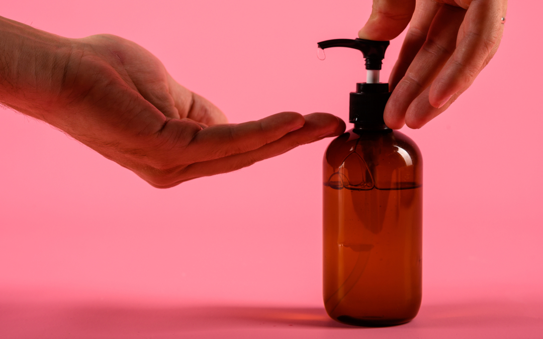 Man hands pushing pump plastic bottle isolated on pink background, clipping path. Mock up